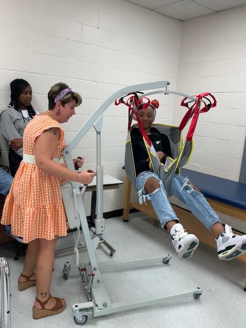 Students learning to use lift equipment