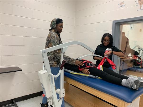 Students learning to use lift equipment